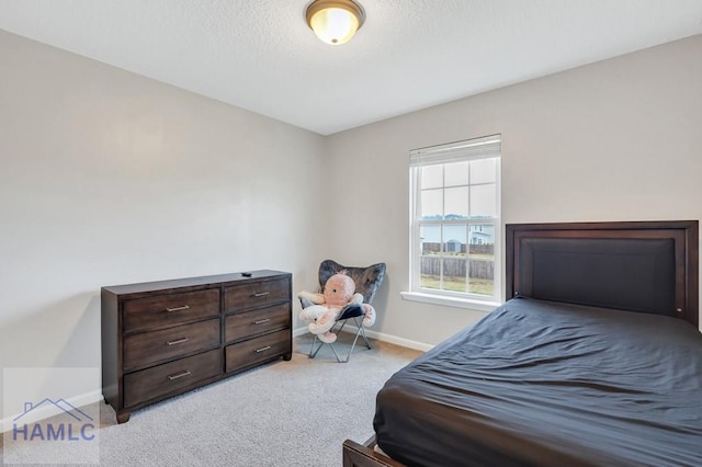 carpeted bedroom featuring baseboards and a textured ceiling