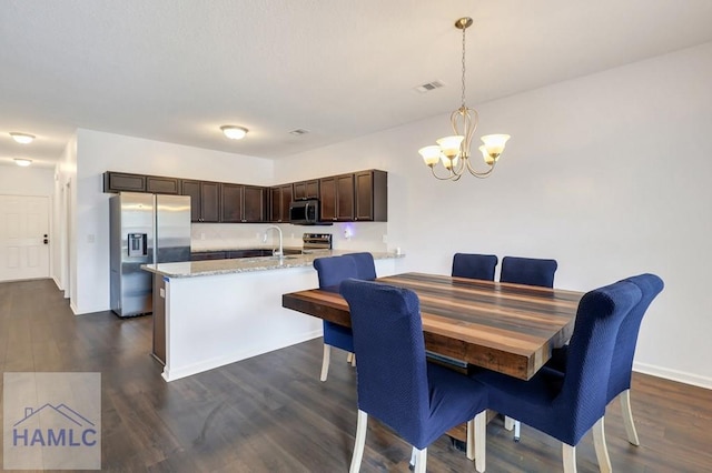 dining space with visible vents, dark wood-type flooring, a notable chandelier, and baseboards