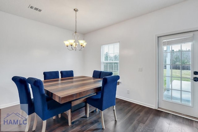 dining room featuring baseboards, wood finished floors, visible vents, and a chandelier