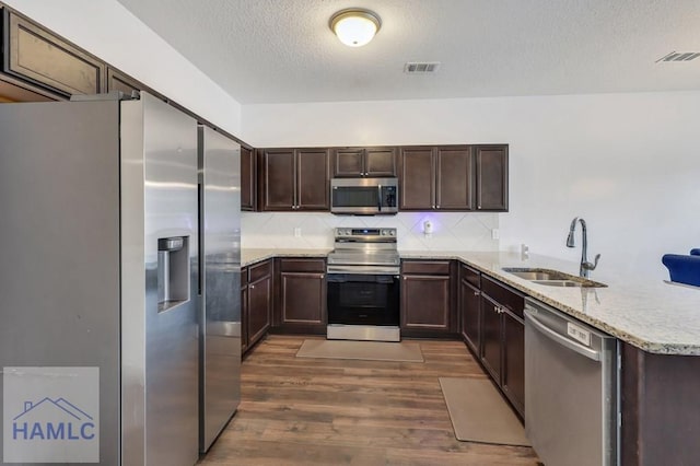 kitchen featuring a sink, visible vents, appliances with stainless steel finishes, and dark wood finished floors