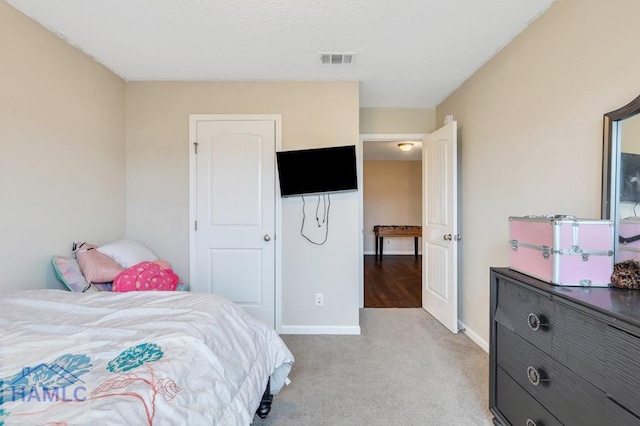 bedroom with light carpet, visible vents, and baseboards