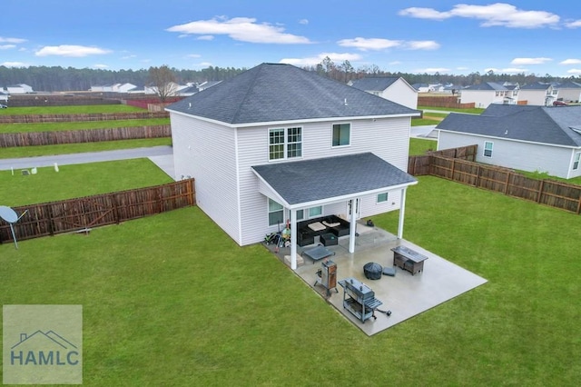 rear view of house with a patio area, a lawn, a shingled roof, and a fenced backyard