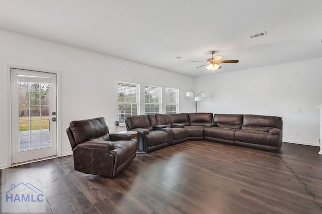 living area with visible vents, baseboards, dark wood-type flooring, and ceiling fan