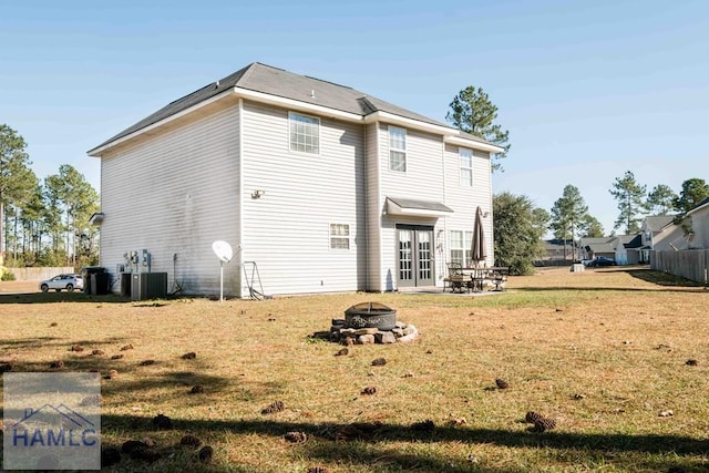 rear view of property with central air condition unit, french doors, a yard, a patio area, and an outdoor fire pit