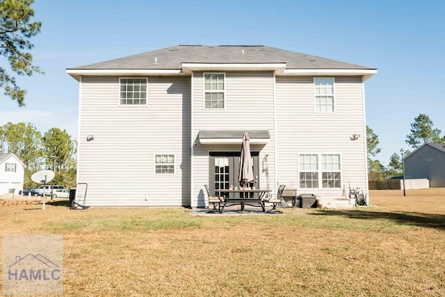 back of house featuring a lawn and a patio area