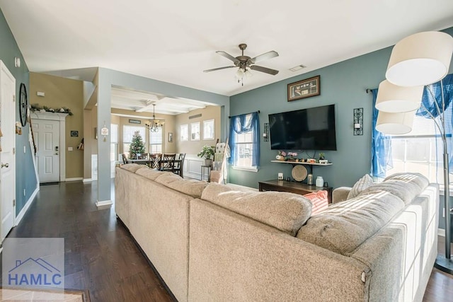 living room featuring ceiling fan with notable chandelier and dark hardwood / wood-style floors