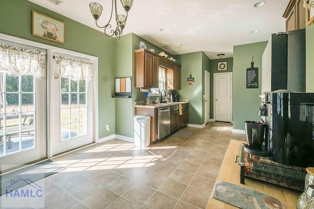 kitchen featuring dishwasher, decorative light fixtures, an inviting chandelier, and sink