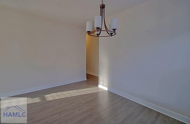 unfurnished dining area featuring wood-type flooring and a chandelier