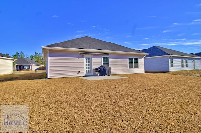 rear view of property with a patio and a lawn