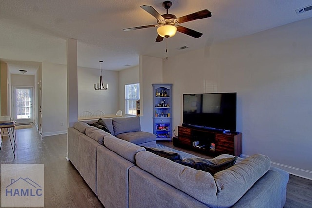 living room with hardwood / wood-style floors and ceiling fan with notable chandelier