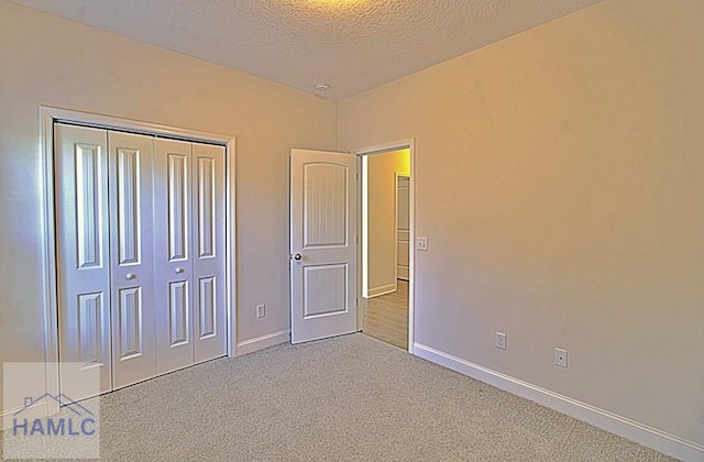 unfurnished bedroom featuring a closet, carpet flooring, and a textured ceiling