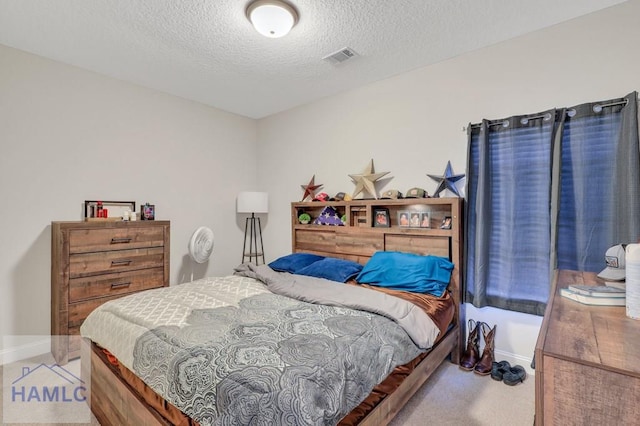 carpeted bedroom featuring a textured ceiling