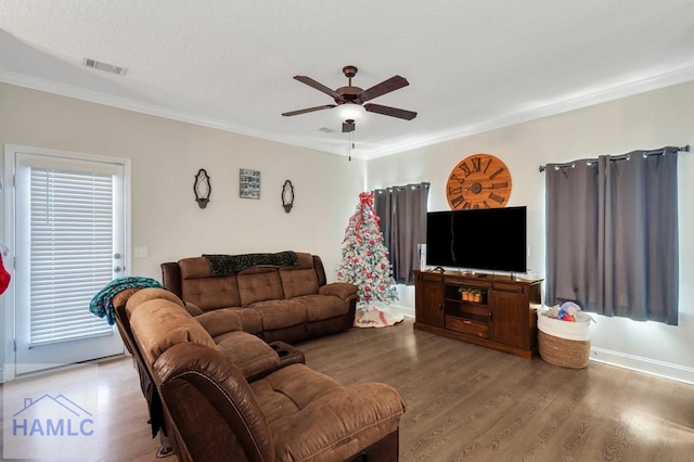 living room featuring ceiling fan, wood-type flooring, and ornamental molding