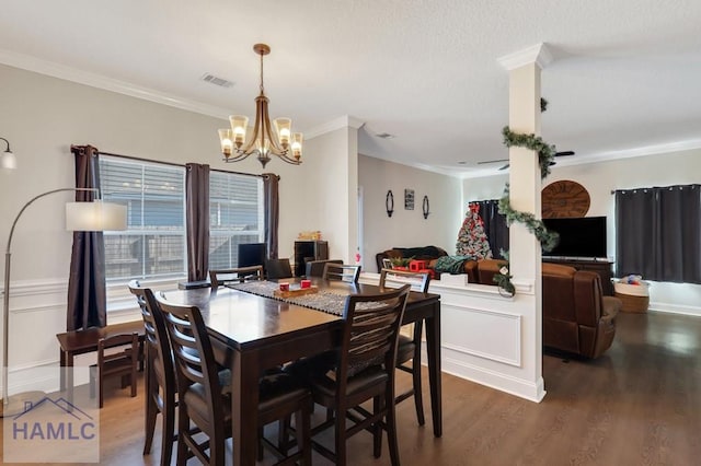 dining area featuring hardwood / wood-style flooring, ornamental molding, and an inviting chandelier