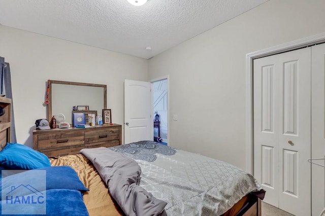 carpeted bedroom with a textured ceiling and a closet