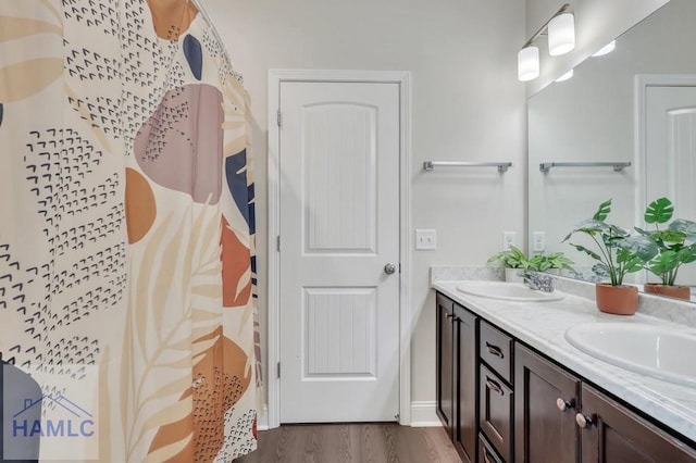 bathroom with vanity, curtained shower, and wood-type flooring