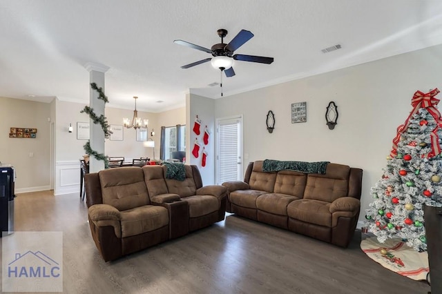 living room with dark wood-type flooring, ceiling fan with notable chandelier, and ornamental molding