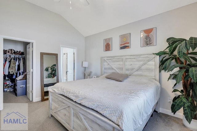 carpeted bedroom featuring a walk in closet, ensuite bathroom, vaulted ceiling, ceiling fan, and a closet