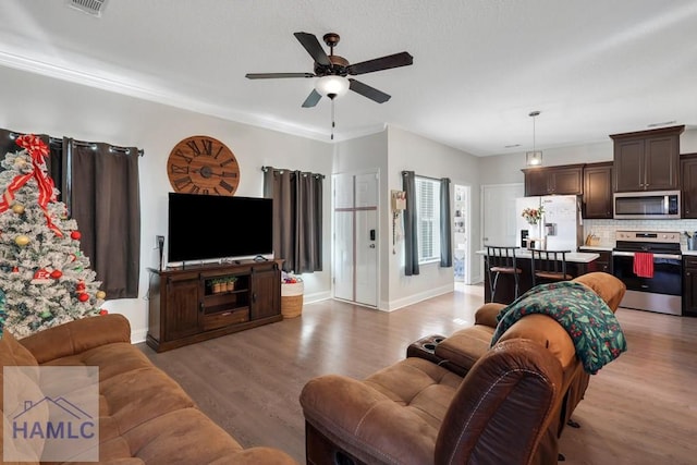 living room featuring ceiling fan, light hardwood / wood-style floors, and ornamental molding