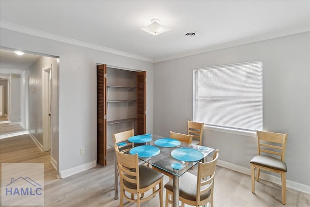 dining area featuring crown molding and light wood-type flooring