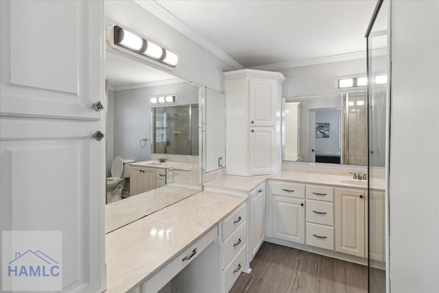 bathroom with hardwood / wood-style floors, vanity, toilet, and crown molding