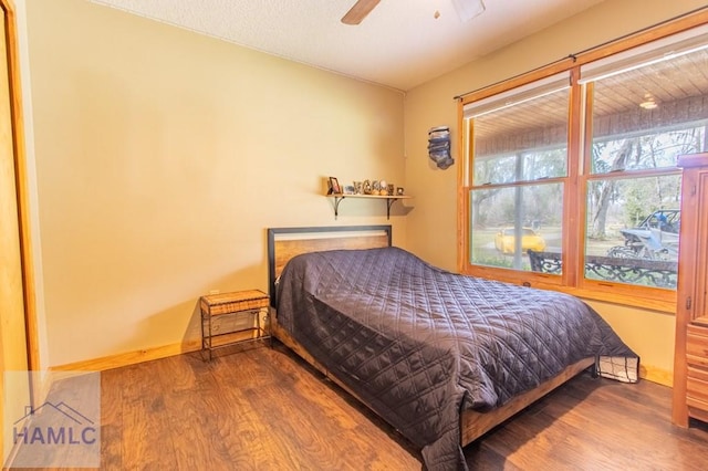 bedroom with ceiling fan, baseboards, and wood finished floors