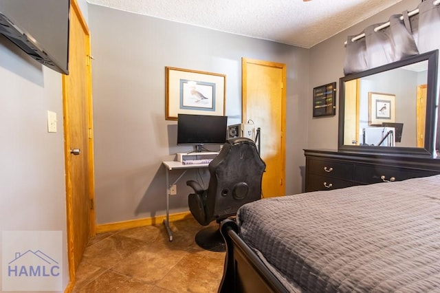 bedroom featuring a textured ceiling and baseboards