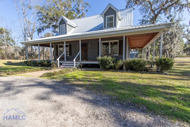 country-style home with metal roof, a porch, and a front lawn