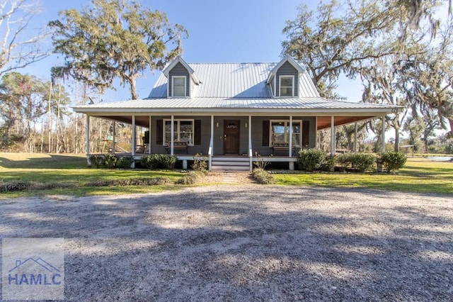 farmhouse featuring metal roof, a porch, and a front yard