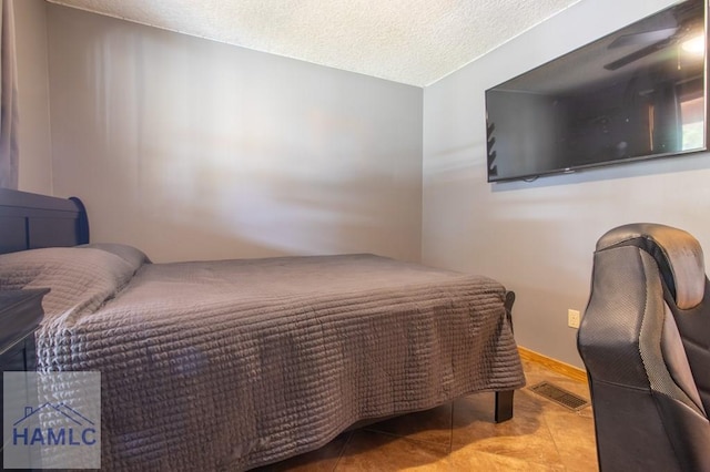 tiled bedroom featuring a textured ceiling and visible vents