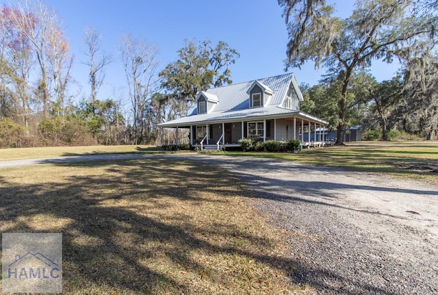 view of front facade featuring covered porch, metal roof, and a front lawn