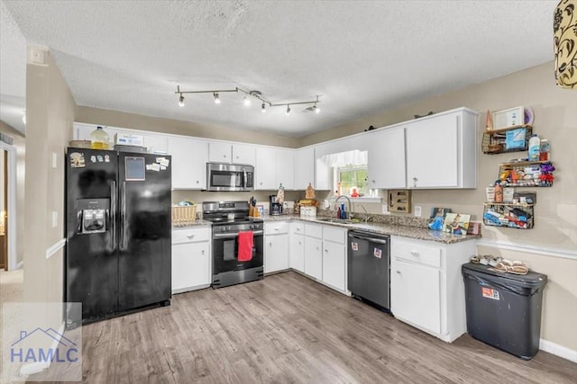 1325 Loblolly Dr, Hinesville, GA 31313 - kitchen with stainless steel appliances, light wood-style flooring, white cabinets, and a textured ceiling
