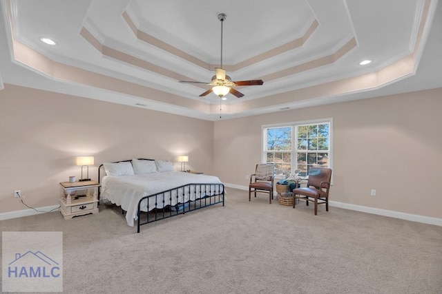 carpeted bedroom with ornamental molding and a tray ceiling