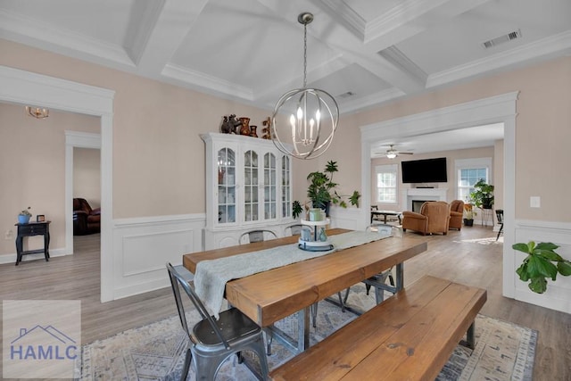 dining area featuring coffered ceiling, beamed ceiling, and light wood-type flooring