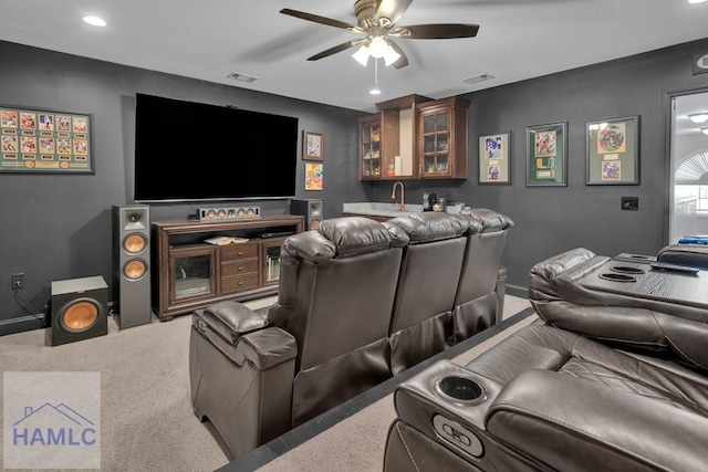 carpeted cinema room with ceiling fan and indoor bar