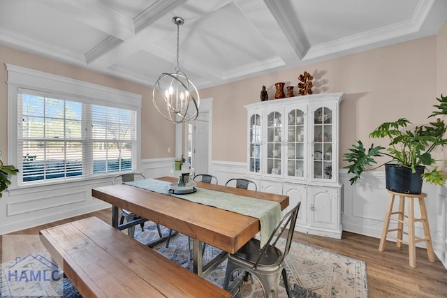 dining room featuring ornamental molding, coffered ceiling, a notable chandelier, light hardwood / wood-style floors, and beam ceiling