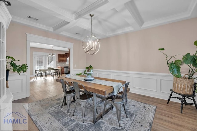 dining area featuring hardwood / wood-style flooring, a notable chandelier, and beam ceiling