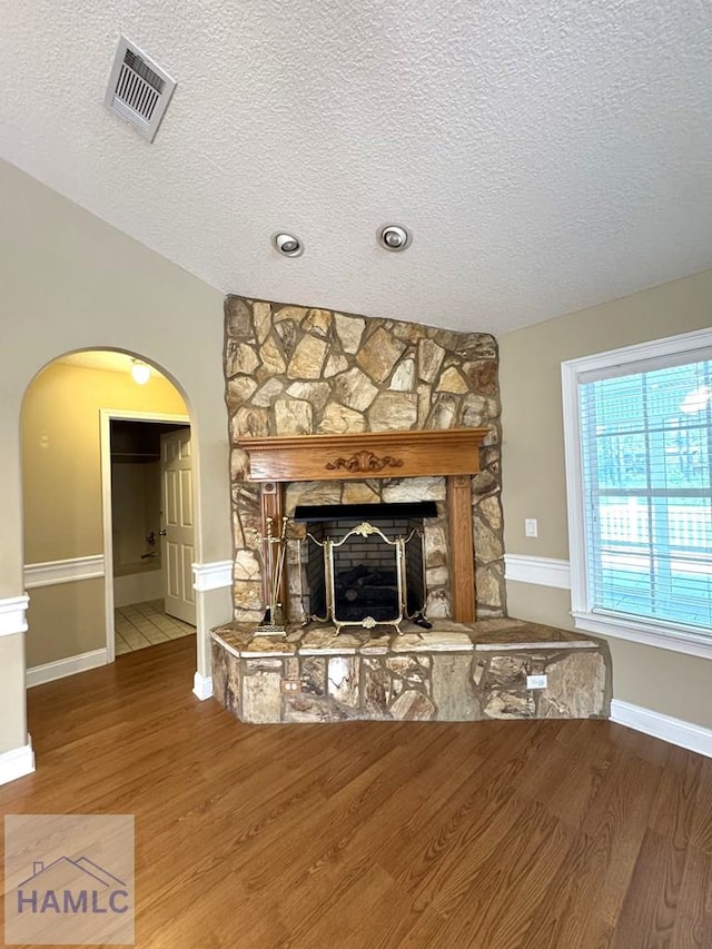 21 Forest Rd, Odum, GA 31555 - unfurnished living room with visible vents, arched walkways, a textured ceiling, and wood finished floors