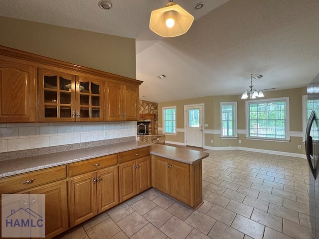 21 Forest Rd, Odum, GA 31555 - kitchen with decorative backsplash, a peninsula, lofted ceiling, glass insert cabinets, and brown cabinets
