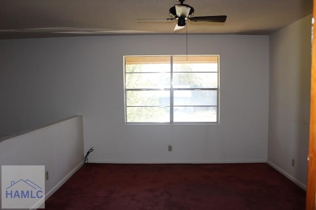 unfurnished room featuring dark colored carpet and ceiling fan