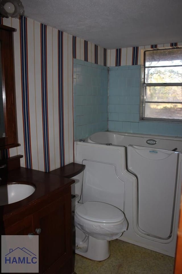 bathroom featuring vanity, a textured ceiling, and toilet