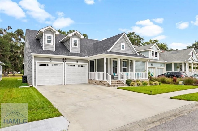 view of front of home featuring a porch, a garage, and a front lawn