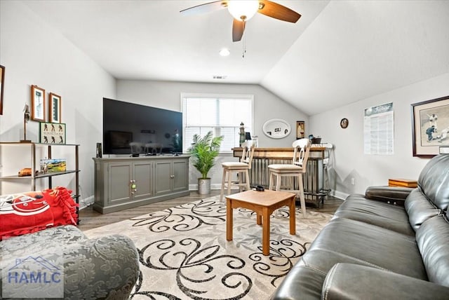 living room with light hardwood / wood-style flooring, vaulted ceiling, and ceiling fan