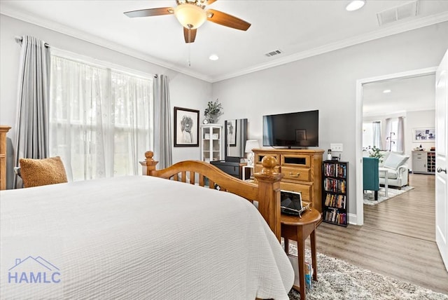 bedroom with ceiling fan, crown molding, and hardwood / wood-style flooring