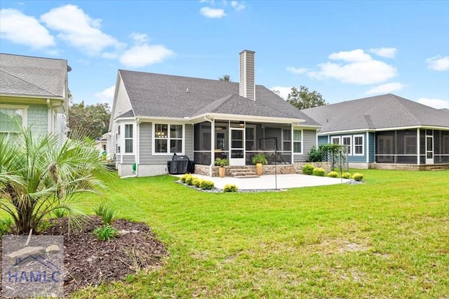 rear view of house featuring a patio, a lawn, and a sunroom