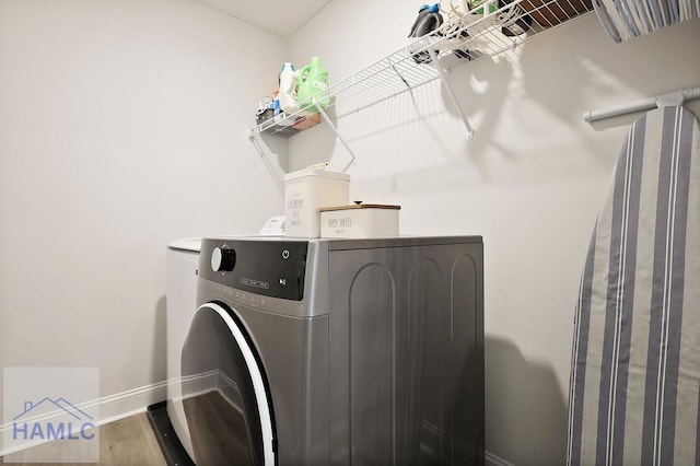 1201 Grayson Ave, Hinesville, GA 31313 - laundry room featuring baseboards, washing machine and clothes dryer, and wood finished floors