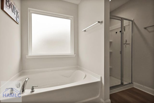 1201 Grayson Ave, Hinesville, GA 31313 - bathroom with a stall shower, a bath, and wood finished floors