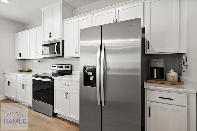 1201 Grayson Ave, Hinesville, GA 31313 - kitchen with appliances with stainless steel finishes, light countertops, white cabinets, light wood-type flooring, and a textured ceiling