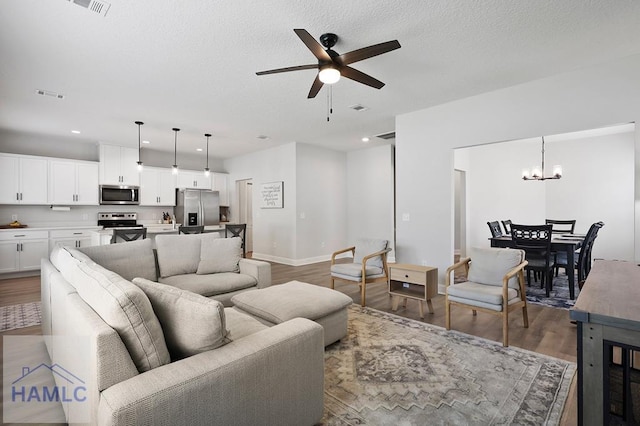 1201 Grayson Ave, Hinesville, GA 31313 - living room with ceiling fan, wood finished floors, recessed lighting, a chandelier, and a textured ceiling