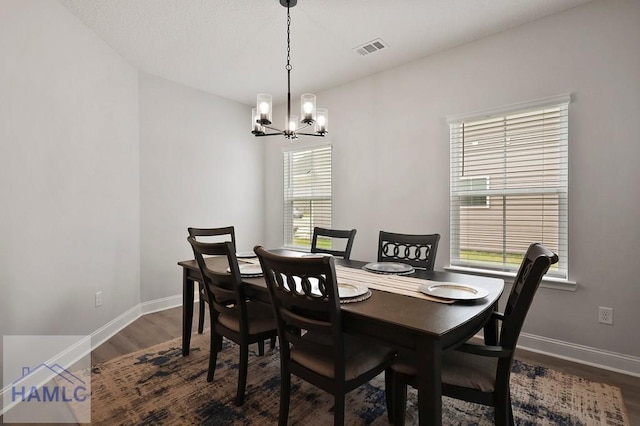 1201 Grayson Ave, Hinesville, GA 31313 - dining area with a chandelier, dark wood finished floors, and baseboards